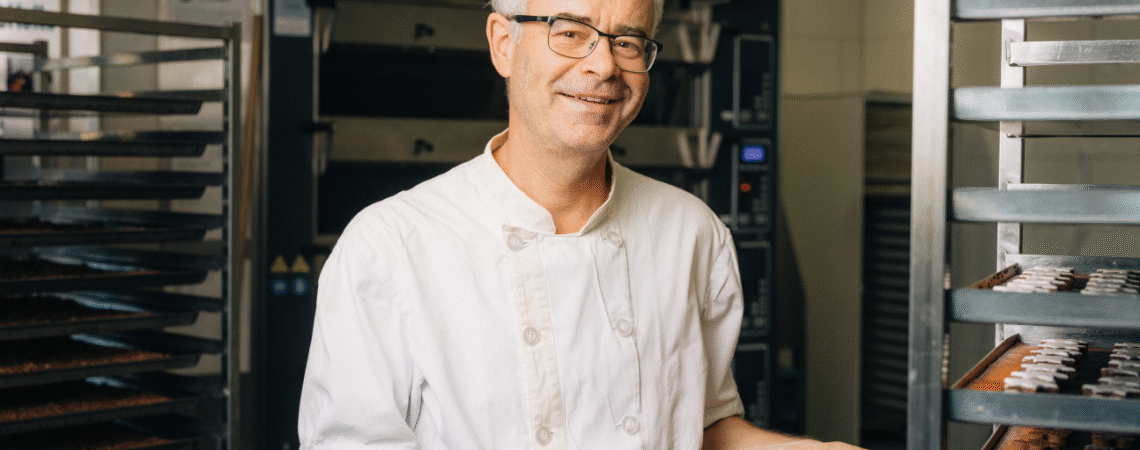 Der Küchenchef zeigt uns eine Platte aus einem Roll-Rack, welche mit Güetzis belegt ist