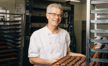 Der Küchenchef zeigt uns eine Platte aus einem Roll-Rack, welche mit Güetzis belegt ist