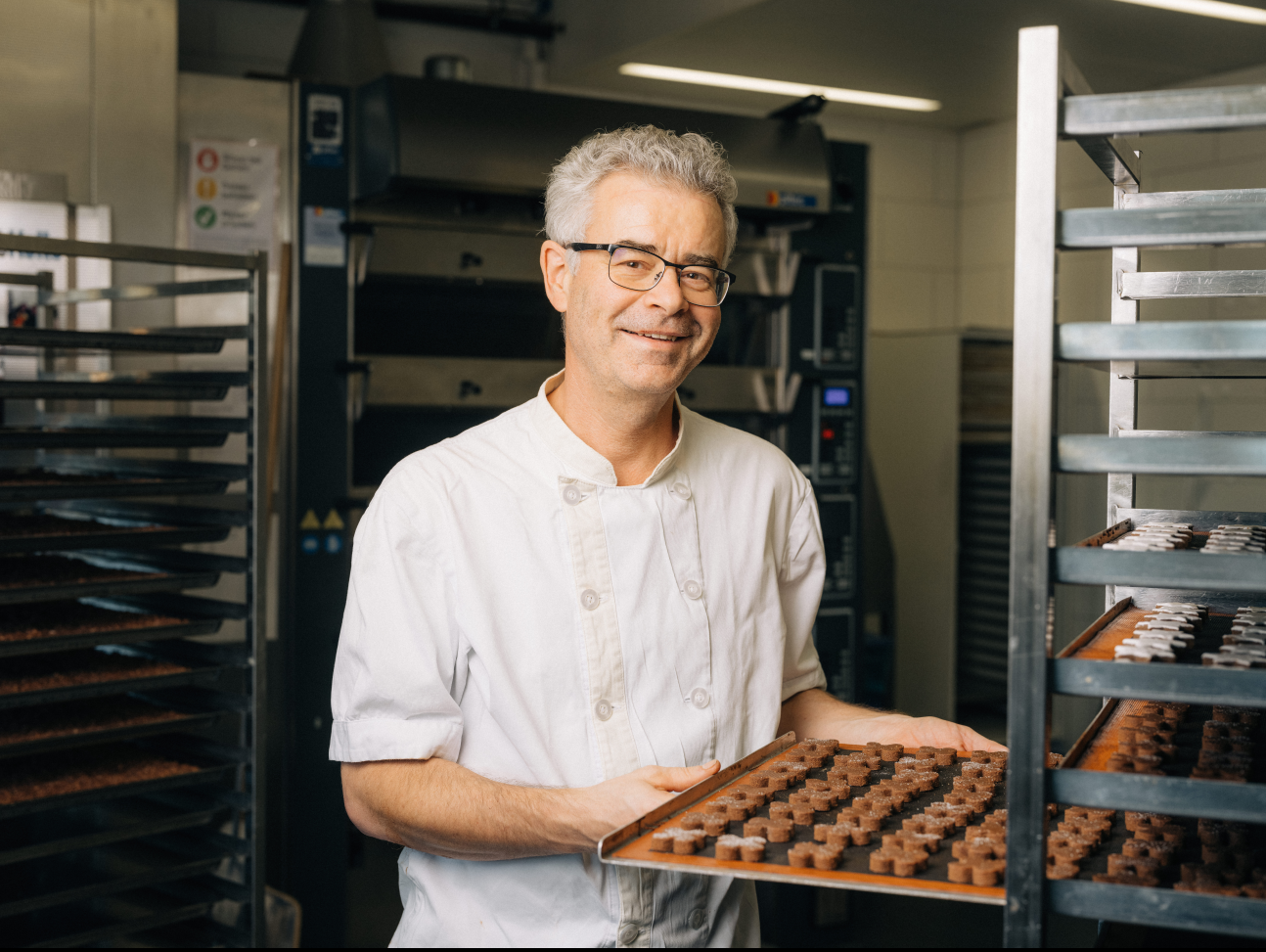 Der Küchenchef zeigt uns eine Platte aus einem Roll-Rack, welche mit Güetzis belegt ist